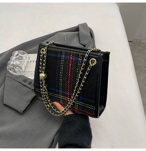 Detailaufnahme der karierten Umhängetasche mit goldener Kette und Metallperle