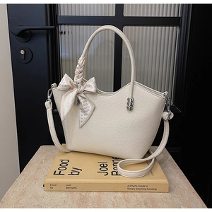 Détail du sac seau blanc cassé avec poignée en foulard de soie et breloques cœur