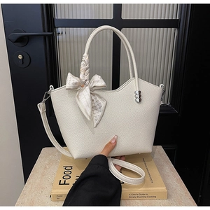 Détail du sac seau en cuir grainé blanc avec foulard en soie et clous en forme de cœur