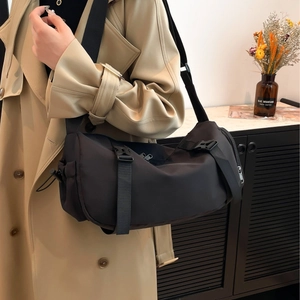 Sac bandoulière cylindrique en nylon noir avec sangle réglable pour trajet urbain