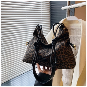 Detail of leopard print canvas tote bag with leather knot handle and fashion label