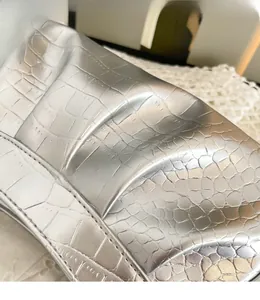 Gros plan du sac plissé argenté avec texture crocodile gaufrée et fini métallisé