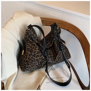 Detailed view of leopard print tote bag with black rope straps and gold metal tips