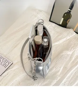 Vue macro de l'intérieur du sac argenté à motif crocodile montrant sa grande capacité