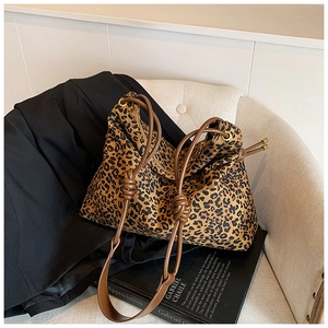 Detail of leopard print tote bag with brown leather drawstring and knotted shoulder strap