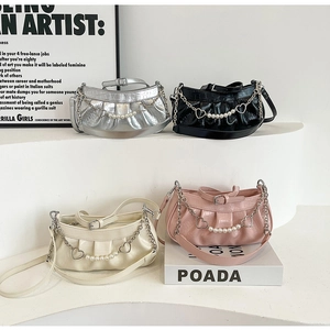 Détail de sacs plissés élégants en argent et noir avec bandoulière chaîne cœur perle