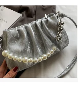 Silver pleated handbag detail with pearl handle and heart-shaped metal chain charm