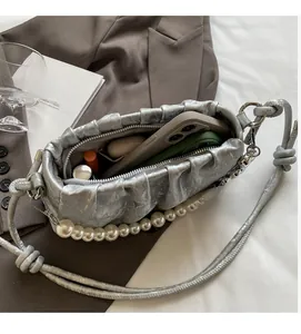 Interior view of silver pleated clutch bag showing storage for phone and accessories