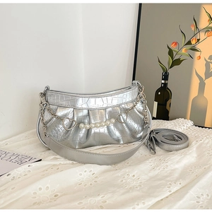 Close-up of silver crocodile pattern bag with pearl chain and heart metal link detail