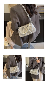 Detail of silver pleated handbag featuring large faux pearl chain strap and metallic finish