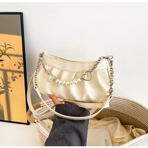 Detail of crocodile pattern leather shoulder bag with pearl and heart metal chain