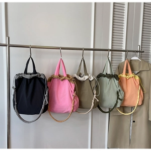 Dettaglio di cinque borse a secchiello in nylon con spalline intrecciate a mano