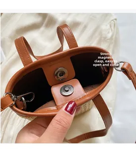 Detail of strong magnetic closure and internal D-ring on striped woven crossbody bag