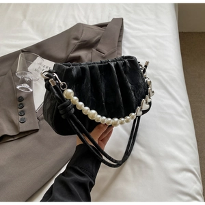 Detail of black pleated bucket bag with pearl and silver heart metal chain handle