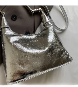 Detail of silver metallic dumpling bag featuring soft pleated texture and silver hardware