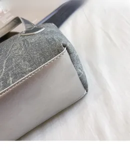 Gros plan sur les coutures précises et la texture du cuir gris du sac seau chic