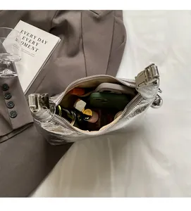 Macro view of interior storage space for silver pleated handbag showing large capacity