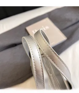Gros plan d'un sac seau argenté avec fermeture éclair de qualité et détails de bord blanc