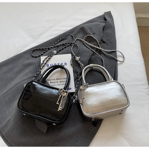 Detail of mini chain handbags in silver and black leather with textured horizontal patterns