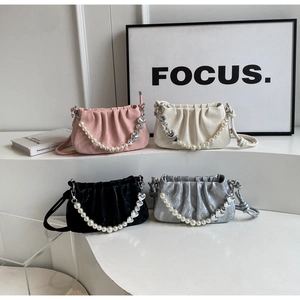 Detailed row of pleated mini handbags in pink, white, black, and silver with pearl chains