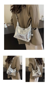 Detail of silver textured hobo bag featuring metallic crackle finish and spherical charm