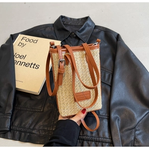 Détail du sac à bandoulière en paille tissée et cuir marron avec sangle réglable