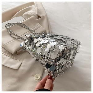 Close-up of shiny silver sequins and metal chain strap on a stylish bucket bag