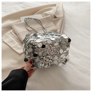 Detailed close-up of sparkling silver sequins and metal chain strap on a luxury bucket bag