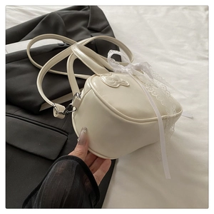 Macro detail of creamy white bag showing elegant lace bow and smooth PU leather texture