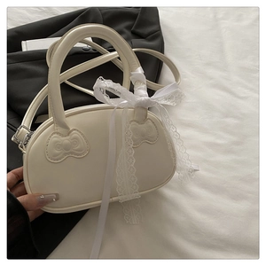 Detailed view of cream white handbag with embossed bows and large lace ribbon detail