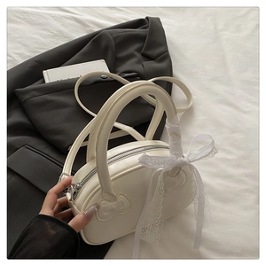 Detail of white glossy mini bag with bow embossing and lace ribbon decoration