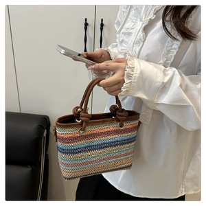 Détail du sac à main tissé à rayures colorées avec anses en cuir marron et anneaux dorés