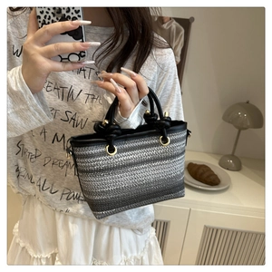 Détail du sac seau tissé avec poignées à nœuds et texture dégradée grise élégante