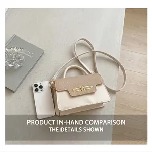 Detail of cream crossbody bag with brown woven flap and golden metal buckle on suit fabric
