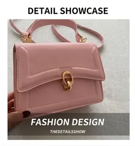 Dettaglio della borsa a trapezio rosa con chiusura a scatto dorata e tracolla