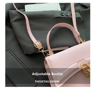 Dettaglio della fibbia regolabile in metallo dorato e catena sulla borsa in pelle rosa