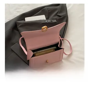 Vista dettagliata dell'interno di una borsa in pelle rosa opaca che mostra la capienza
