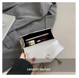 Detail view of the interior space showing capacity for phone and cosmetics in the white bag