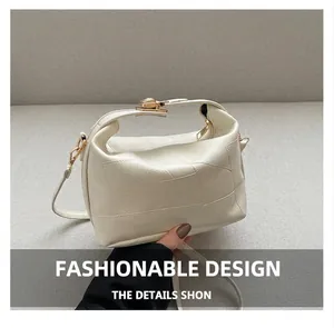 Détail du sac crème avec texture tissée, boucle en métal et bandoulière réglable