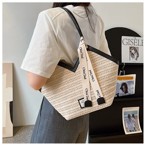Elegante borsa tote in paglia intrecciata con spalline in pelle PU nera indossata dal modello