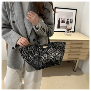 Detailopname van een grote shopper met luipaardprint gecombineerd met een grijze mantel