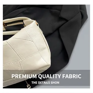 Gros plan sur le cuir grainé blanc et le fermoir en métal doré d'un sac seau élégant