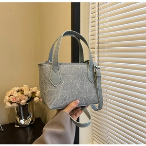 Gros plan du sac seau bleu clair à motif marbré avec détails argentés et poignée