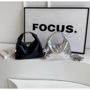 Detail of minimalist Hobo bags with silver metal handles and glossy patent leather finish