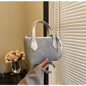 Détail du sac cabas en denim gris avec motifs floraux et anses métallisées argentées