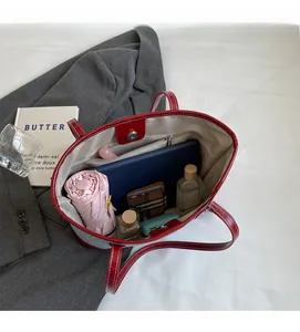 Spacious interior of red leather tote bag showing large capacity for laptop and daily essentials