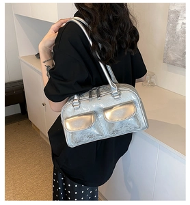 Close-up of silver oil wax leather shoulder bag with dual front flap pockets and mirror finish