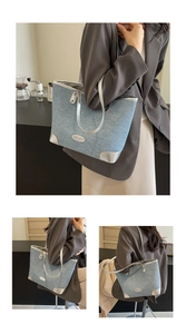 Detail of blue denim tote bag with silver leather trim and oval metal logo accent