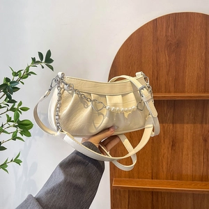 Chic pleated off-white shoulder bag with pearl chain and heart charms in a natural setting