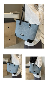 Detail of denim tote bag showing black leather stitching and large capacity design